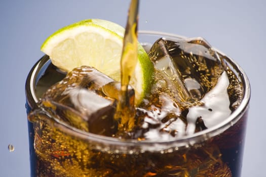 refreshing glass of cola with lemon and ice isolated