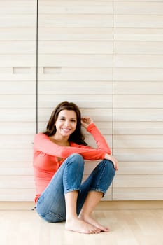 A young woman sitting on the floor at home