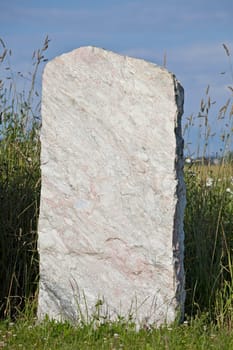 single empty granite gravestone on a grass meadow