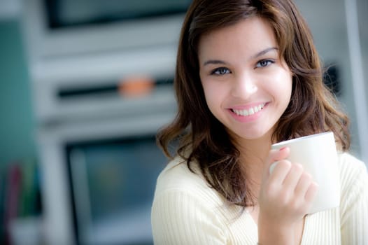 A young woman having coffee in the kitchen