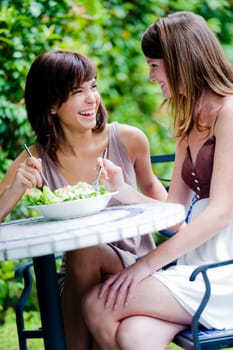 Two young attractive women having lunch together outside