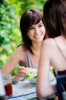 Two young attractive women having lunch together outside