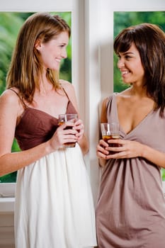 Two women standing together with glasses of ice tea