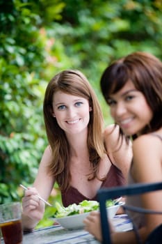 Two young attractive women having lunch together outside