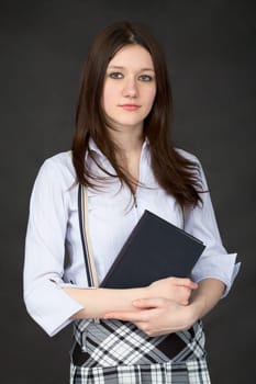 Girl with the book in hands on a black background