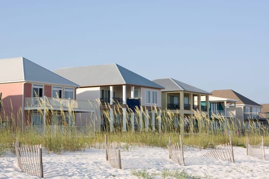Vacation rental homes sit among the sea oats along the coastline.