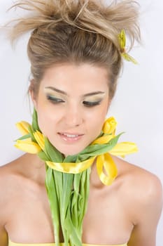 Close-up fresh funny blonde with beautiful make-up with tulips