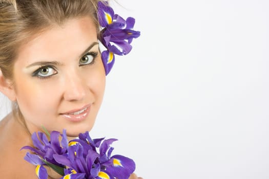 Close-up fresh funny blonde with beautiful make-up with iris flowers