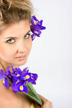 Close-up fresh funny blonde with beautiful make-up with iris flowers