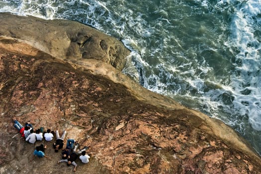 Many friend are relaxing on rock of sea shore