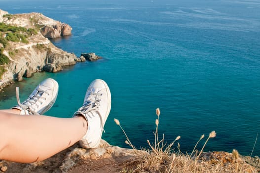 Tired feet of traveller on the top of the rock in Fiolent bay