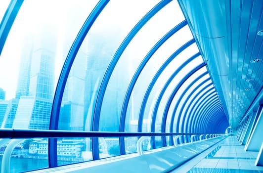 Glass corridor in modern business centre. Tint Blue