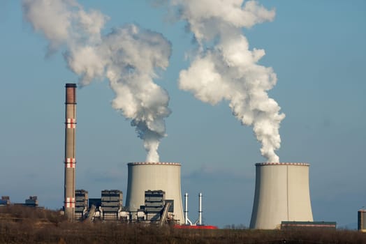 Smoke rises from a power plant to the sky