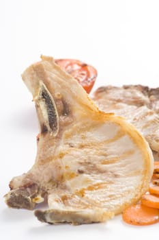 tasty pork chop with corn carrot tomato isolated