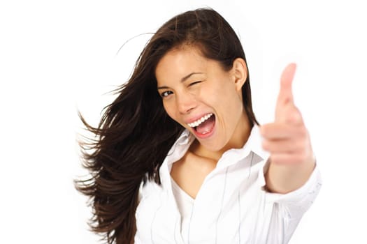 Beautiful woman giving tumbs up / pointing while blinking. Isolated on white background.
