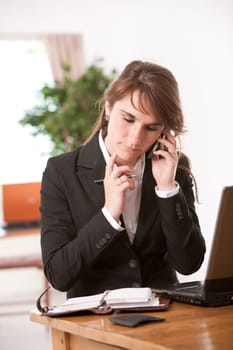 Attractive young businesswoman looking in her diary