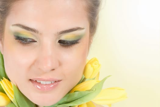 Close-up fresh blonde with beautiful make-up with tulips
