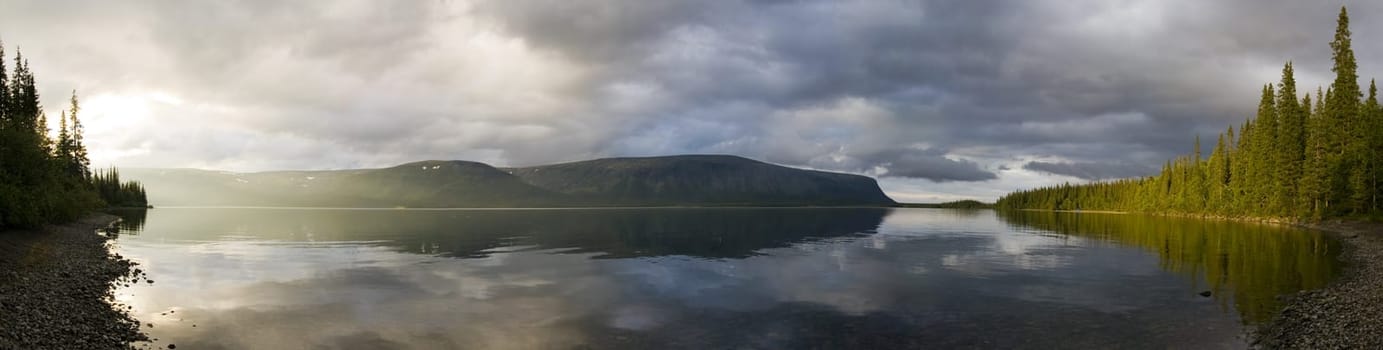 Panorama of a sunlitted foggy lake