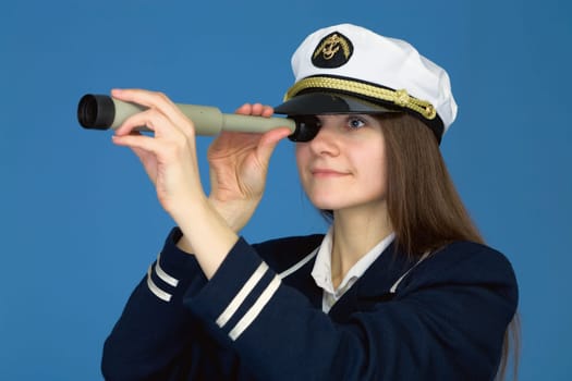 Portrait of the woman - captain with telescope on a blue background