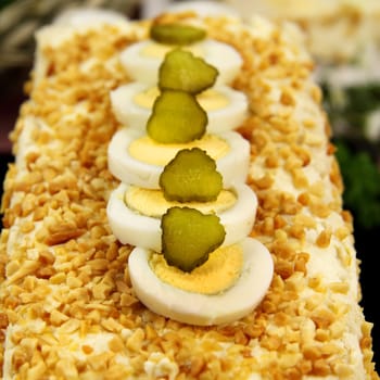 Boiled eggs and gherkins on top of cheese and nuts.
