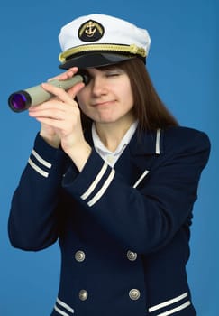 Portrait of the woman - captain with spyglass on a blue background