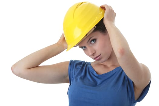 Young female architect or builder wearing a yellow hart hat on a construction site