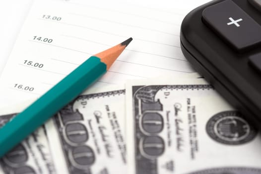 Dollar bills,pen and calculator close up