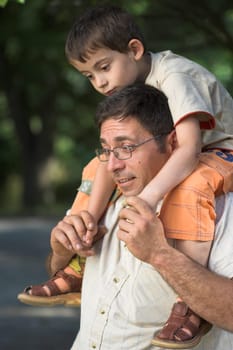 Man giving a little boy piggyback ride