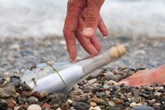 Transparent glass bottle with a note on seacoast