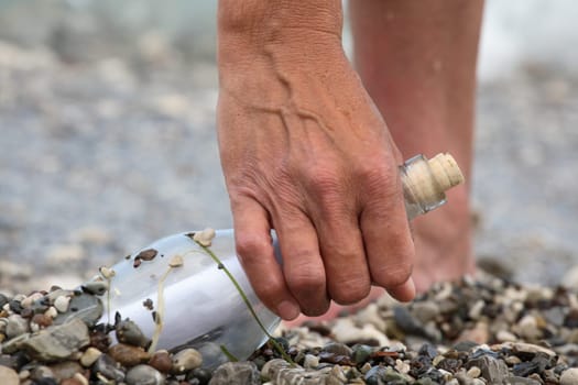 Transparent glass bottle with a note on seacoast
