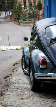Old black car parked on a steep street