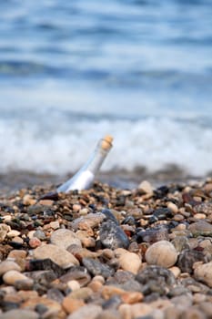 Transparent glass bottle with a note on seacoast