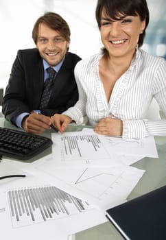 business couple is smiling at camera while making an analyses