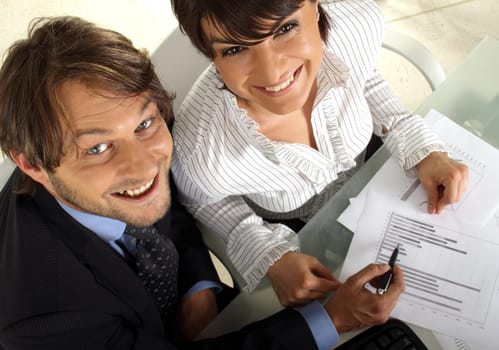 two smiling business people are making an analyses together