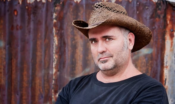 Mature man with gray stubble in a cowboy hat