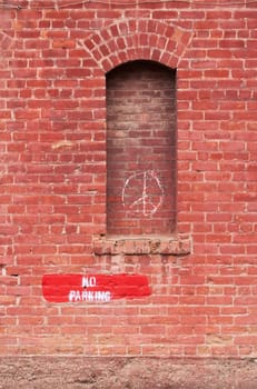 Brick wall with no parking and peace signs