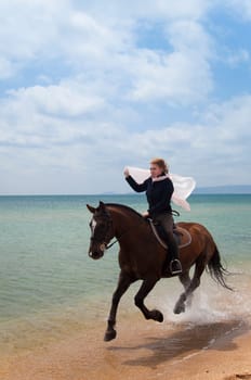 Girl on a horse galloping along the beach