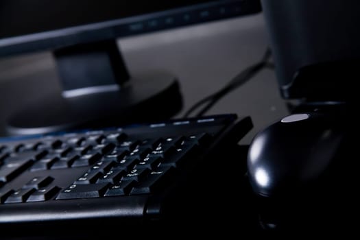 Black desktop computer on desk with mouse, keyboard and monitor