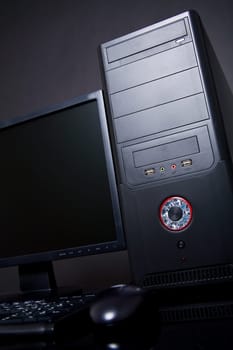 Black desktop computer on desk with mouse, keyboard and monitor