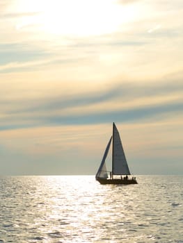 sailboat on the water at dusk with great clouds