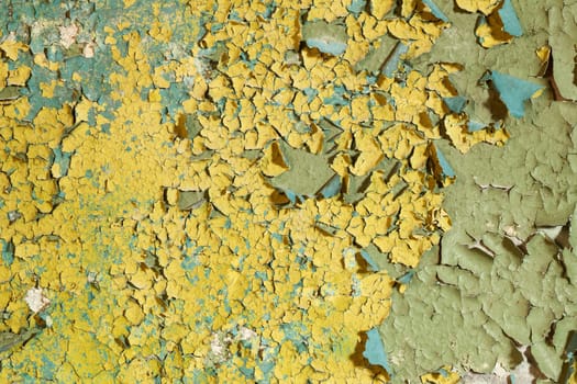 Old damaged yellow paint on a concrete wall background