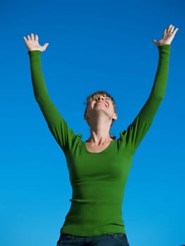 Portrait of the young woman posing on a background of the dark blue sky