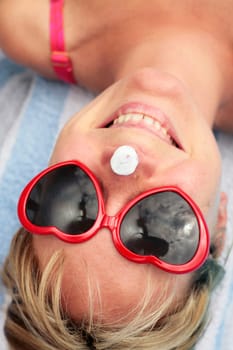 Woman laughing with sunscreen on her nose