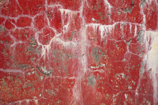 Red dirty cracked concrete wall background with stains