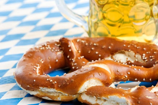 Close-up of one Bavarian Oktoberfest pretzel with beer stein (mug)
