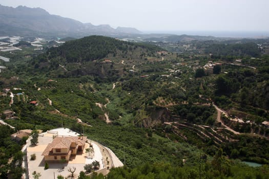 A modern villa in the spanish mountains amongst orange groves. The view is out towards the Costa Blanca with the Mediterranean Sea in the distance.
