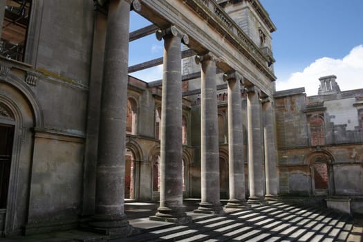 The steps and pillars of an entrance to Witley Court, a once-magnificent country house in Worcestershire, England, which was ravaged by fire in 1937 and now stands as an empty shell.
