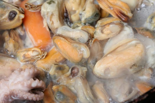 Seafood cooked with vegetables in a pan.