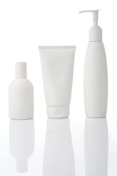 Three white cosmetic bottles stand on a white background