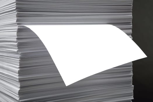 The white pure leaf which is sticking out of a pile of a paper